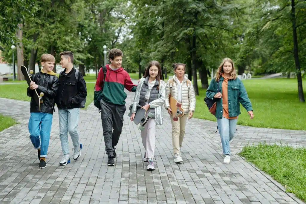 grupa nastolatków idąca chodnikiem
