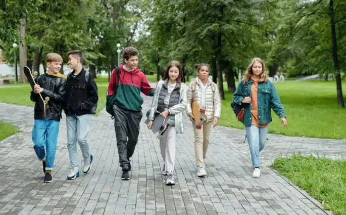 grupa nastolatków idąca chodnikiem