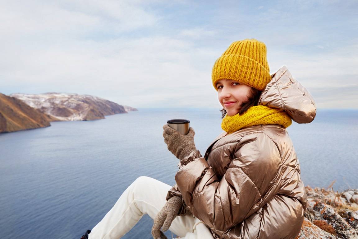 a-smiling-girl-traveler-drinks-hot-tea-from-a-ther-2023-08-07-22-27-48-utc.jpg